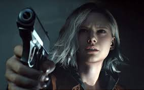 Um close-up de Ashley Graham, de Resident Evil 4, com uma expressão assustada, olhando para cima. No primeiro plano, uma arma de mão está visível.